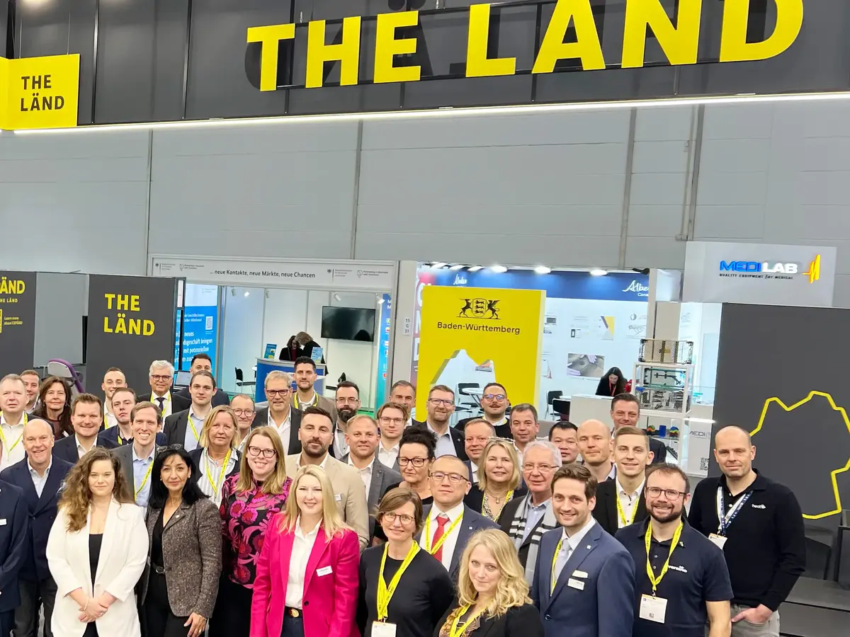 Zwei Personen betrachten ein medizinisches Instrument an einem Messestand.
