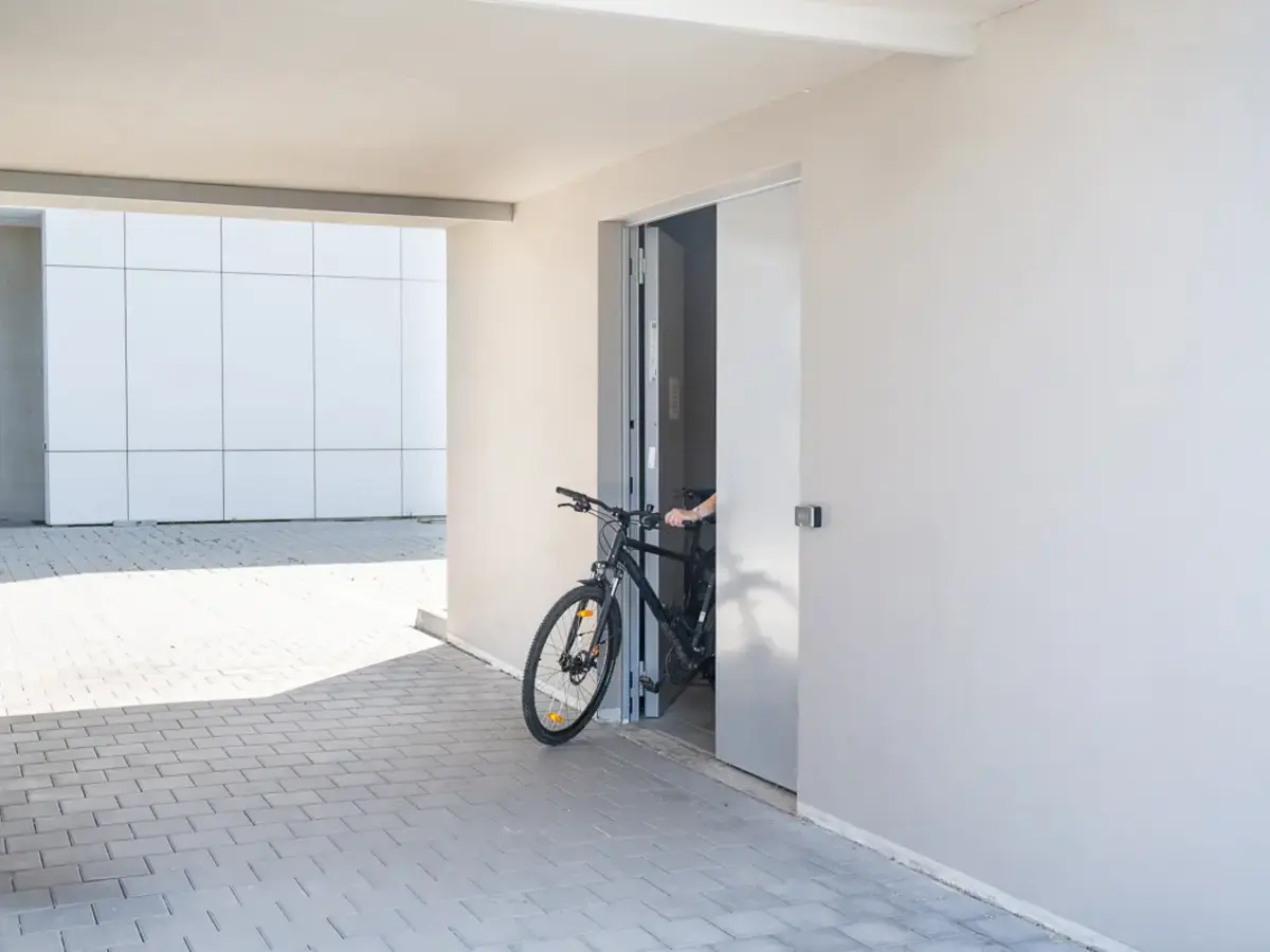 Bright interior space with bicycle parked near a wall and a large wall mirror.