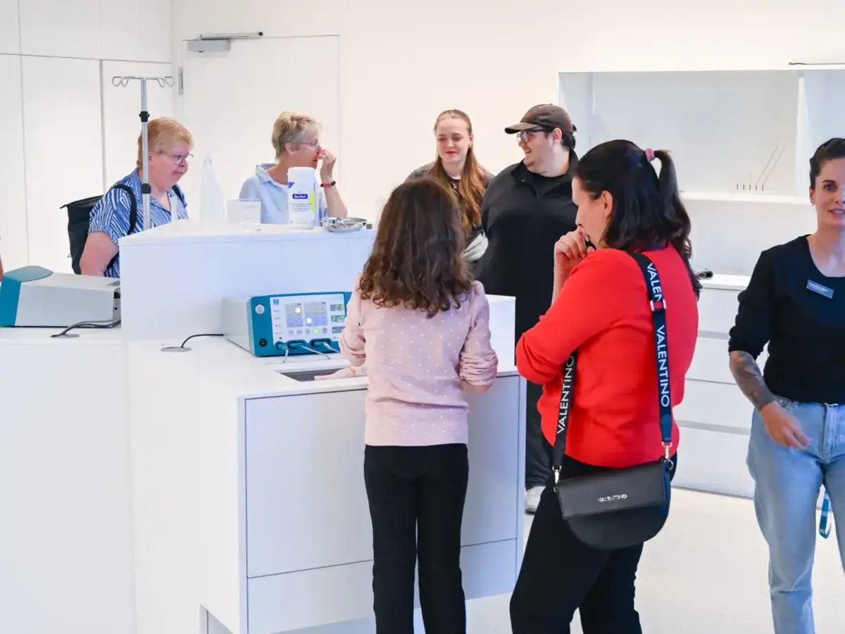 Besuchergruppe betrachtet Medizintechnik-Geräte während einer Führung durch das Unternehmen.