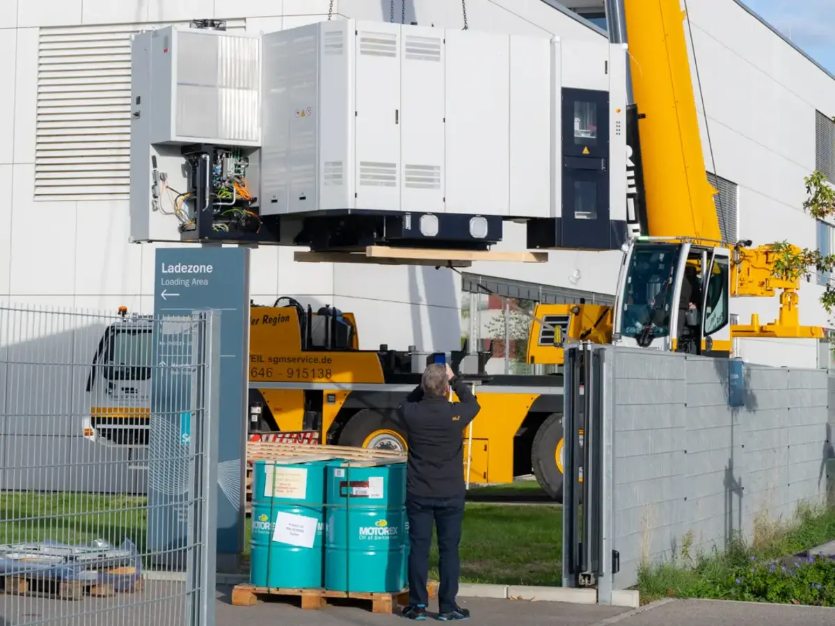 Mobilkran hebt große Produktionsanlage über Betriebsgelände zur Installation.