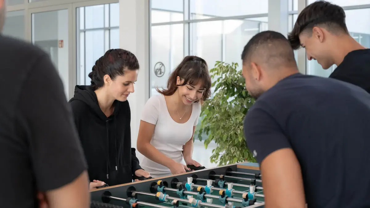Auszubildende bei Sutter Medizintechnik spielen gemeinsam am Kickertisch – Teamevent und Spaß in der Ausbildung.