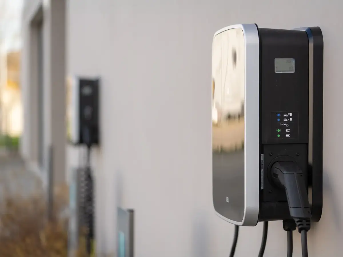 Mehrere Wallboxen für Elektroautos an einer Gebäudewand im Außenbereich.