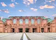 Frontansicht des Nationaltheaters Mannheim mit eindrucksvoller historischer Sandsteinfassade unter einem malerischen Abendhimmel.