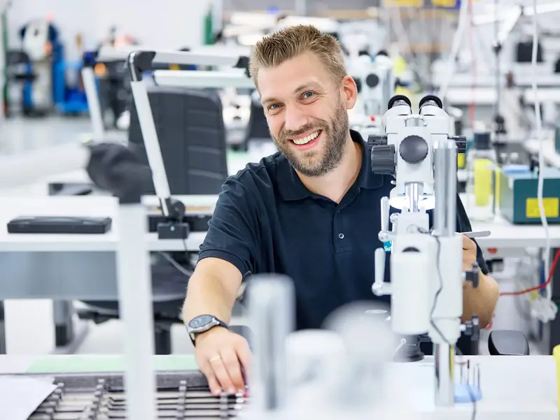 Porträt eines lächelnden Mitarbeiters bei Sutter Medizintechnik in der Produktion – Engagement und Präzisionsarbeit in der Medizintechnikfertigung.