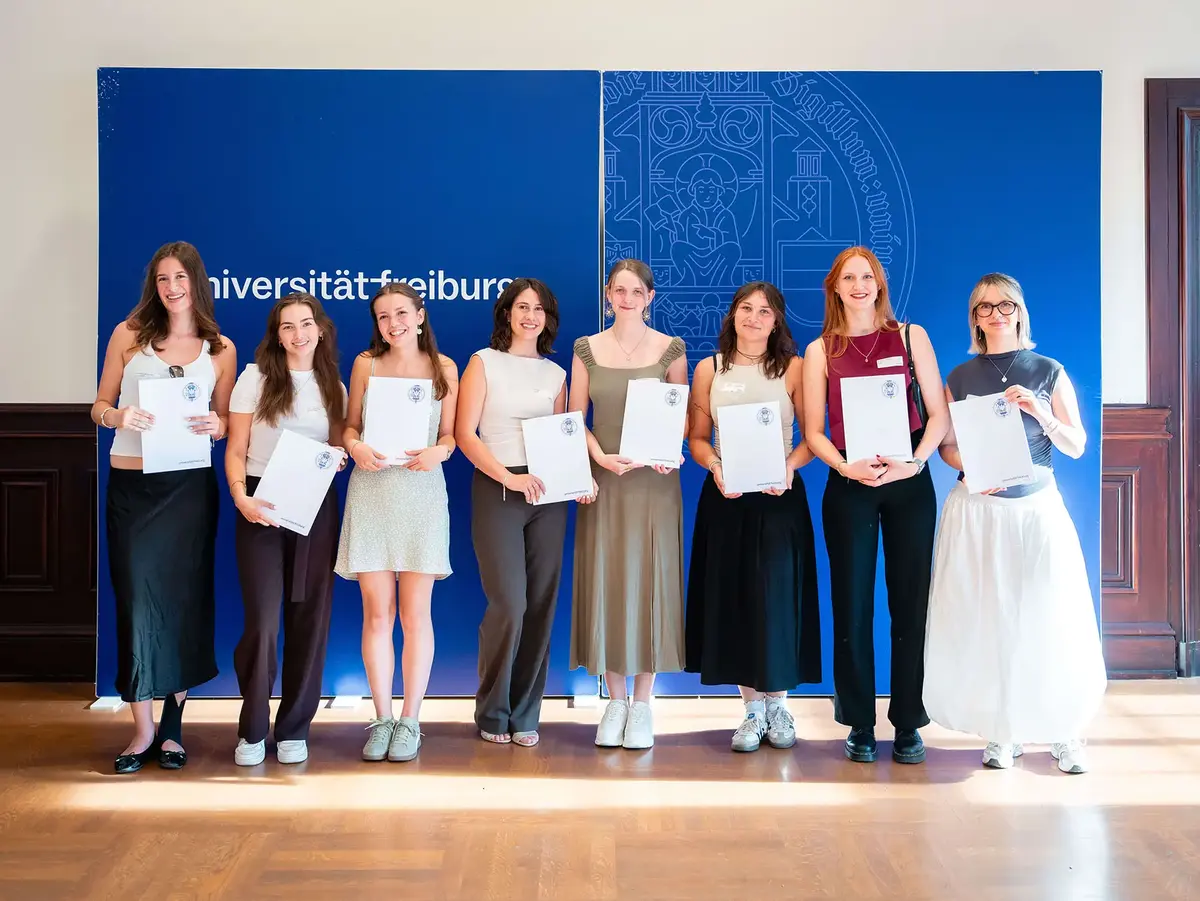 Gruppenfoto von Stipendiatinnen und Stipendiaten vor einer Präsentationswand der Universität Freiburg. Die Aufnahme steht für akademische Förderung, Bildungsengagement, Talententwicklung und erfolgreiche Teilnahme an einem Stipendienprogramm.