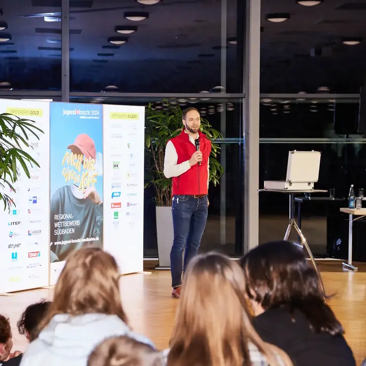 Präsentation eines Gewinnerteams vor Publikum bei einer Veranstaltung.