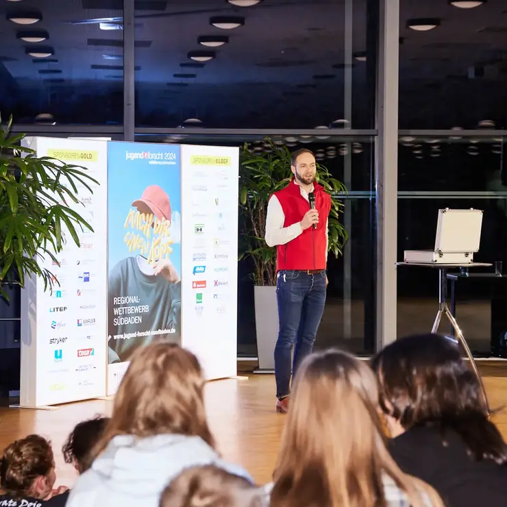 Presentation of an award-winning team in front of an audience at an event.