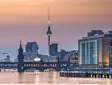 Berlin TV Tower and Oberbaum Bridge at sunset above the River Spree.