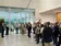 Eine größere Besuchergruppe steht im Foyer und hört einem Vortragenden im modernen Firmengebäude zu.