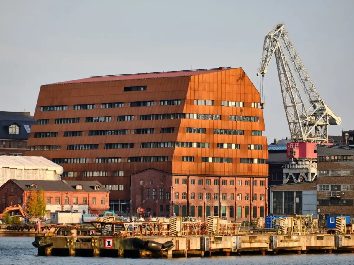 Markantes modernes Backsteingebäude an einem Hafen mit Wasser und Stadtkulisse.