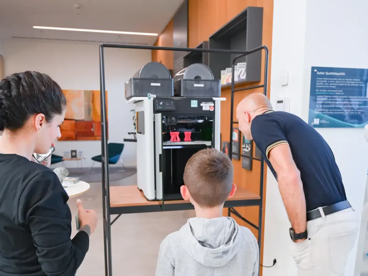 Besuchende beobachten einen 3D-Drucker bei einer Live-Demonstration während der Nacht der Ausbildung.