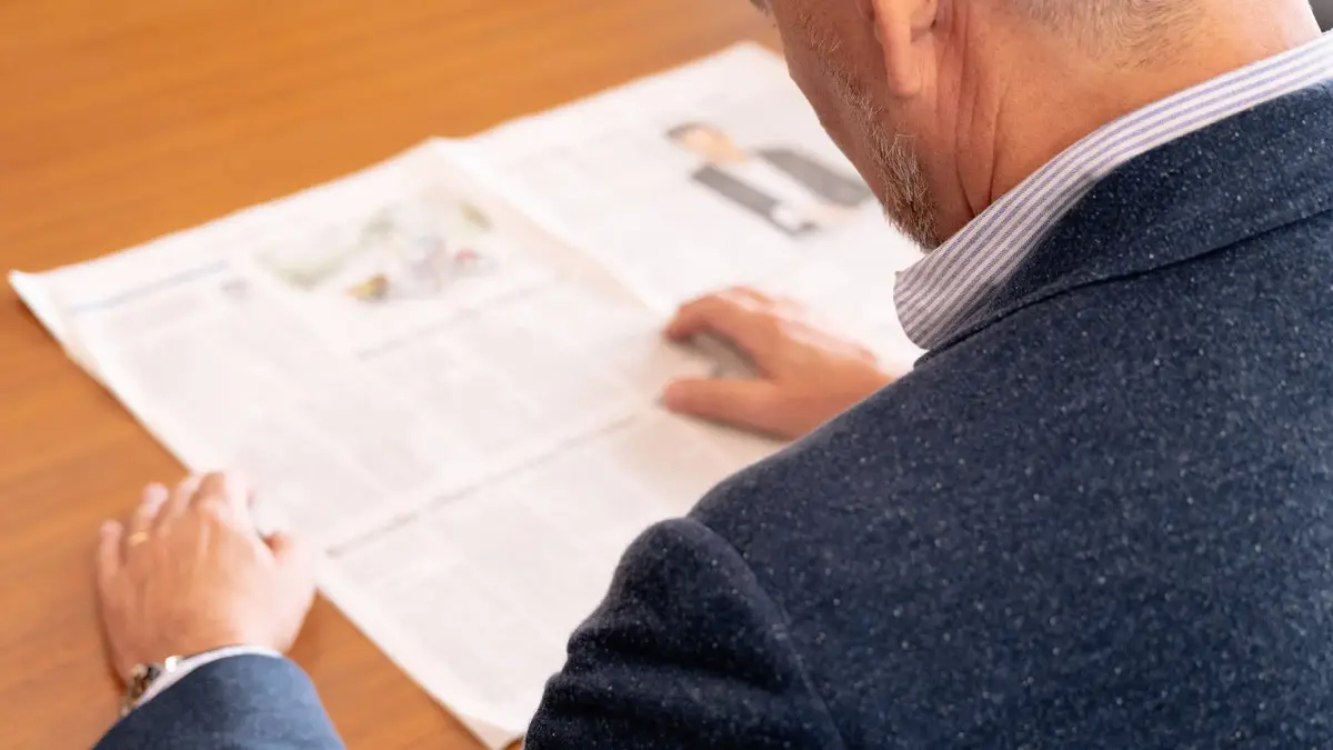 Bert Sutter liest einen Zeitungsartikel über Sutter Medizintechnik – aktuelle Berichterstattung zum Unternehmen.