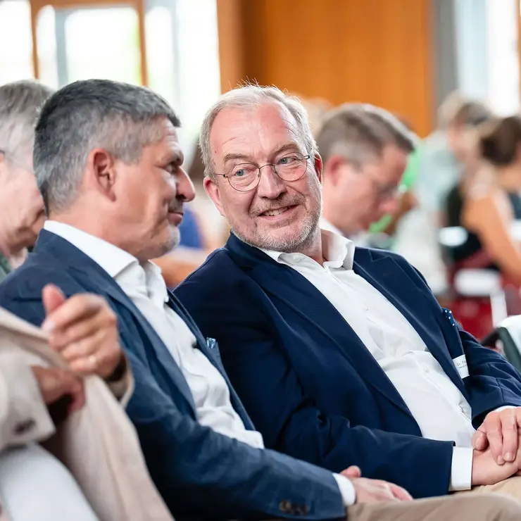 Teilnehmende einer Veranstaltung der Universität Freiburg im persönlichen Austausch vor Beginn oder während eines Programmpunkts. Die Aufnahme steht für akademisches Networking, Kooperation und den Dialog zwischen Fördernden, Hochschulvertreterinnen und Hochschulvertretern sowie Studierenden.