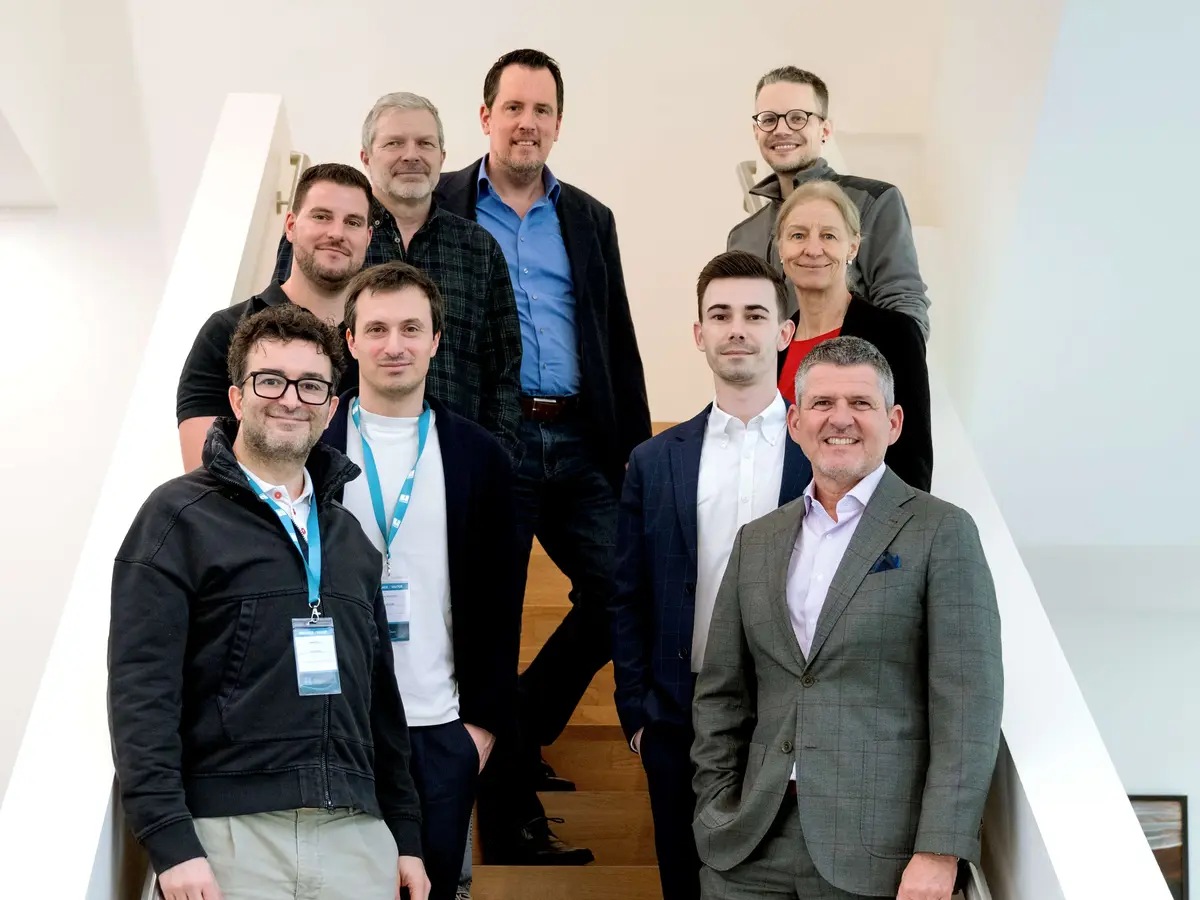 Group of employees standing on a staircase in a modern office and business building.