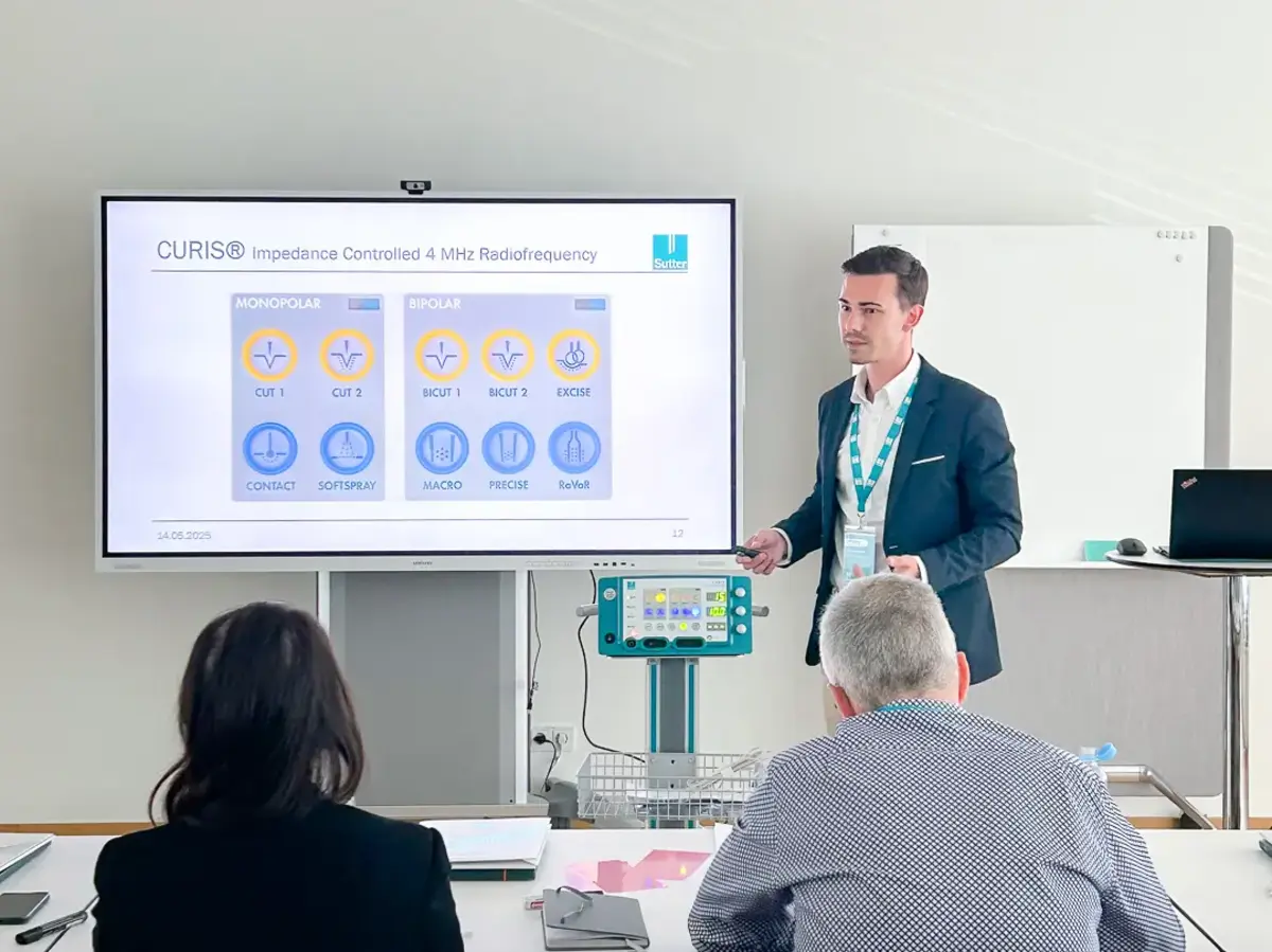 Person presenting content on a screen to attendees in a seminar room.