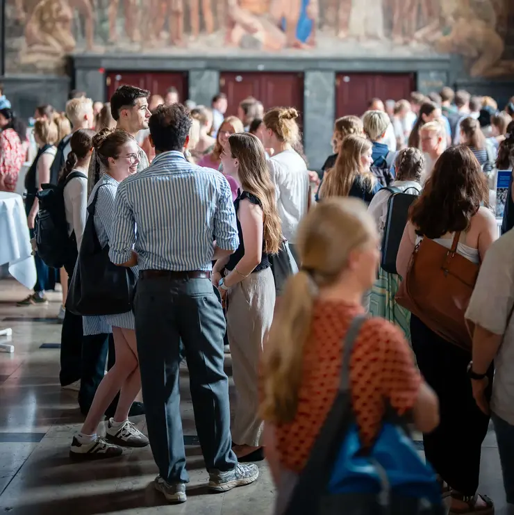 Networking event in the historic setting of the University of Freiburg. The image highlights personal interaction, knowledge exchange, and community building within an academic environment.