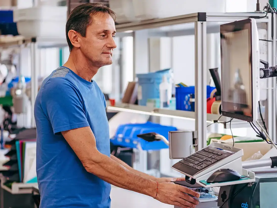 Ein Mitarbeiter von Sutter Medizintechnik bedient eine Fertigungsmaschine in der Produktion – Fokus auf Präzision und Effizienz