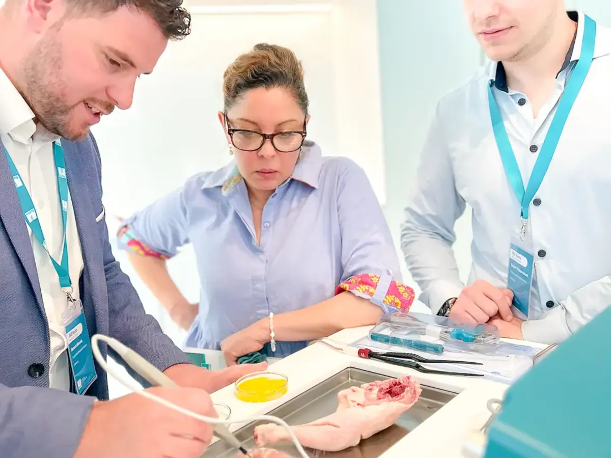 Several people examining a technical setup together at a worktable.