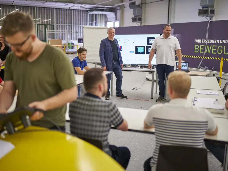 Employees attending a technical presentation and training session in an industrial facility.