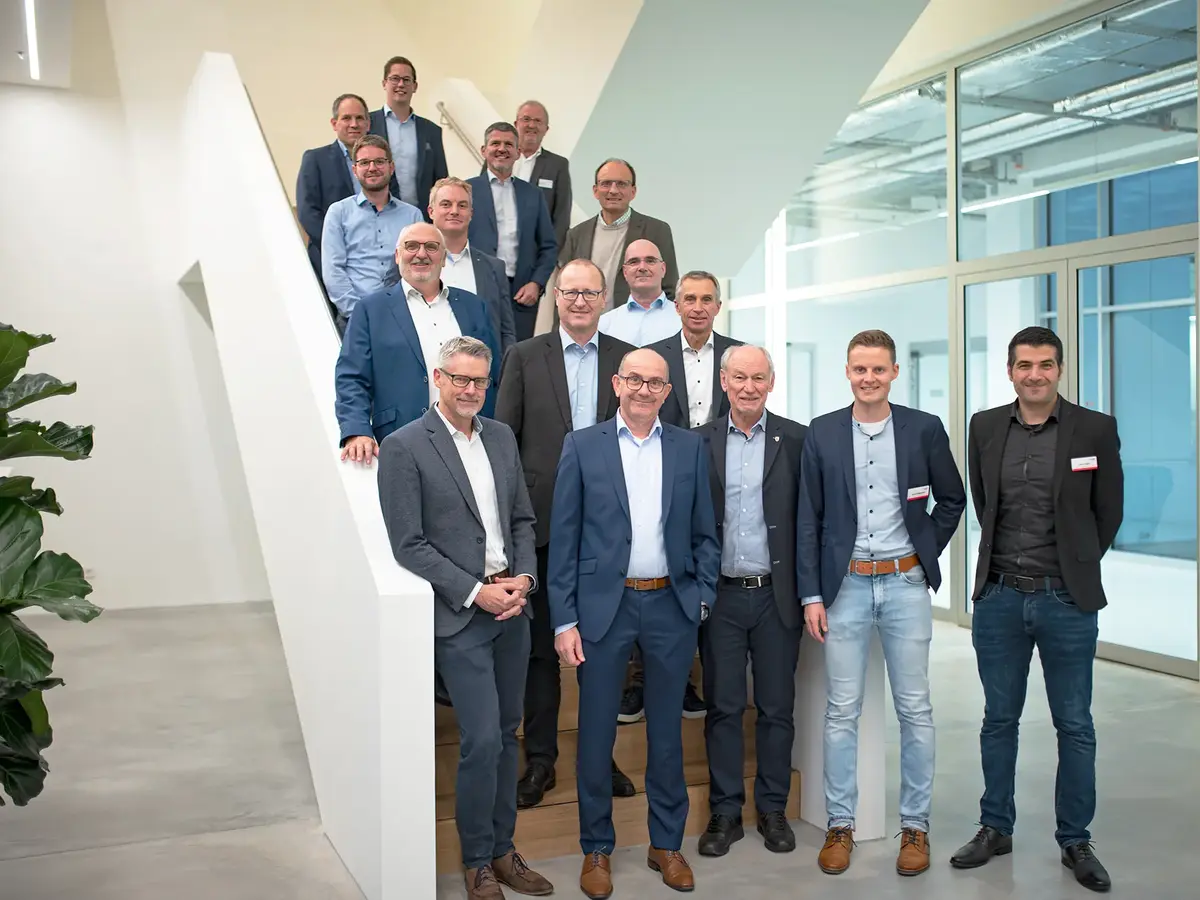 Group photo of wvib Medical Technology Cluster participants on a staircase in a modern corporate building.