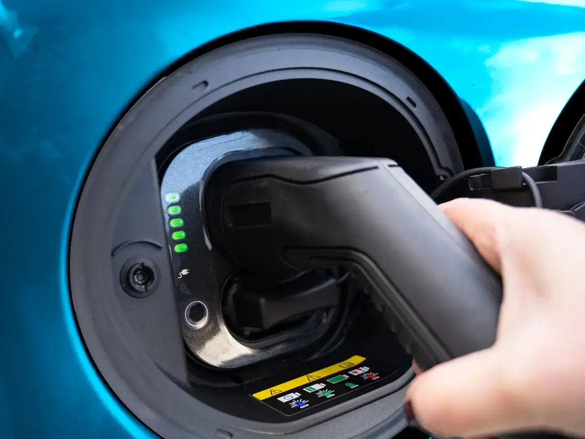 Ladestecker wird in den Ladeanschluss eines Elektroautos eingesteckt.
