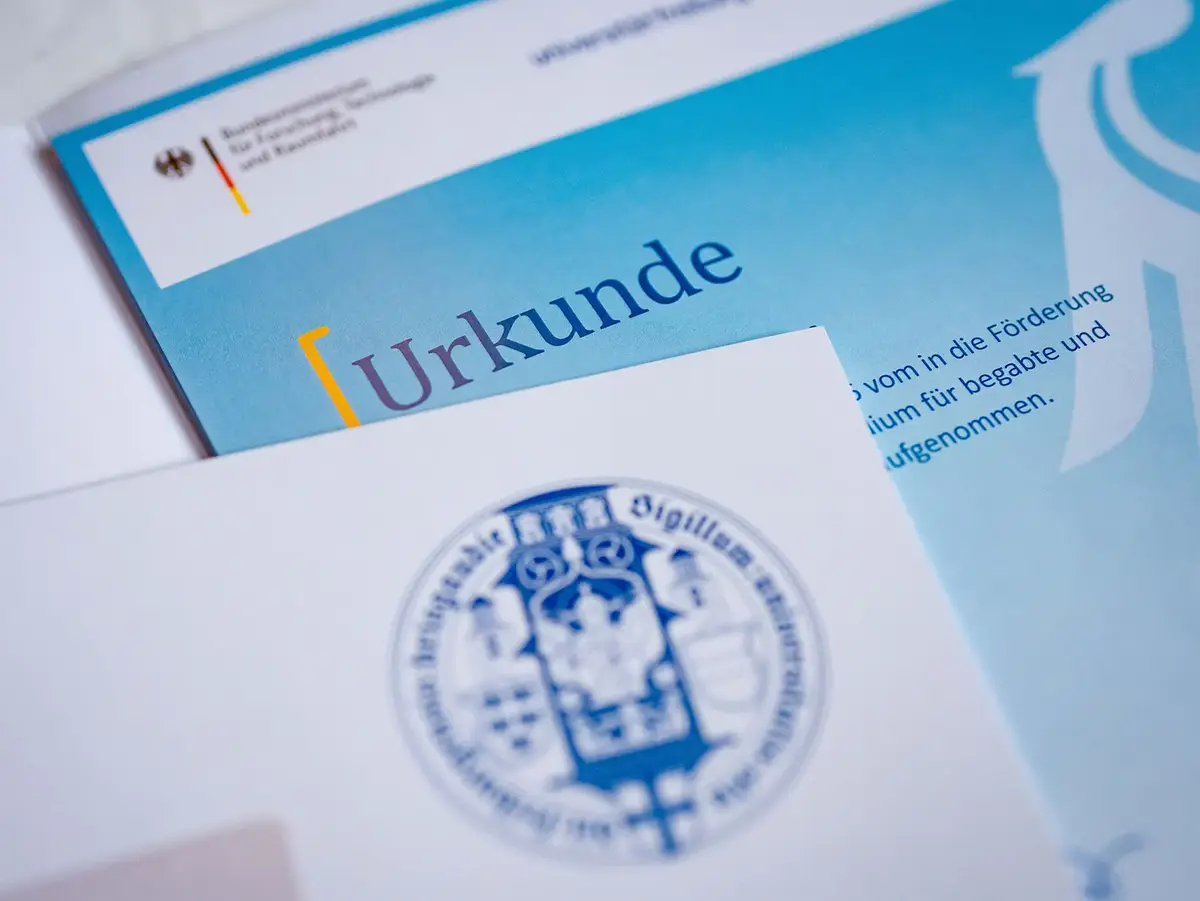 Urkunde und offizielle Dokumente im Kontext von Bildung, Förderung und akademischer Auszeichnung. Die Nahaufnahme symbolisiert Anerkennung von Leistungen, Stipendienprogramme und erfolgreiche Qualifizierung.