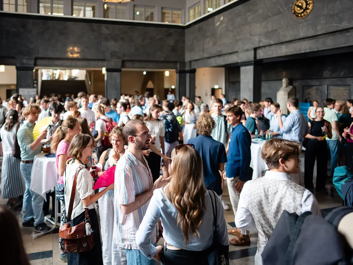 Netzwerkveranstaltung mit zahlreichen Teilnehmenden in einem repräsentativen Foyer. Die Aufnahme zeigt intensive Gespräche, Wissensaustausch und persönliche Begegnungen in einem professionellen Eventumfeld.