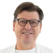 Prof. Dr. Torstein R. Meling mit Brille und in Arztkittel vor weißem Hintergrund.