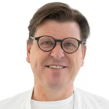 Prof. Dr. Torstein R. Meling mit Brille und in Arztkittel vor weißem Hintergrund.