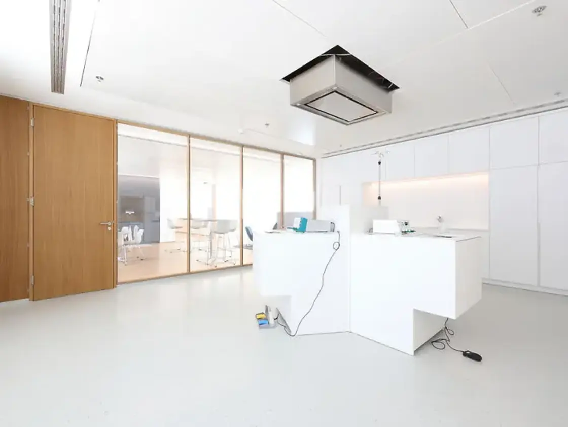 sutter-medizintechnik-schulungsraum © Kiefer und Sohn GmbH.jpg Heller Schulungsraum bei Sutter Medizintechnik mit modernem Equipment, weißen Möbeln und Glasfront zum angrenzenden Pausenbereich.