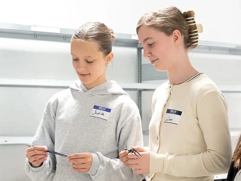 Praktische MINT- und Technikförderung: Zwei Teilnehmende untersuchen Bauteile während eines Workshops in einer modernen Ausbildungsumgebung.