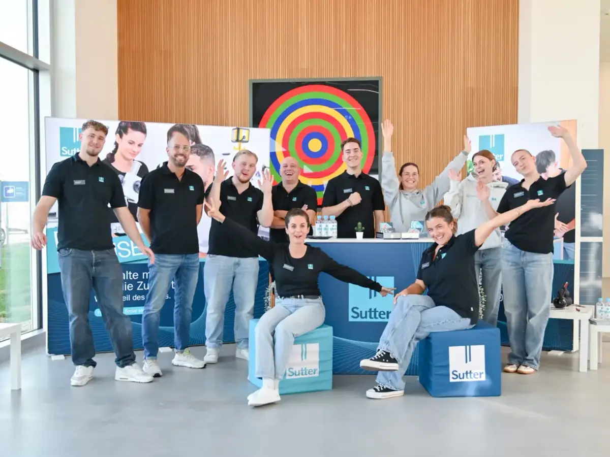 Group photo at an apprenticeship information stand with apprentices and employees.