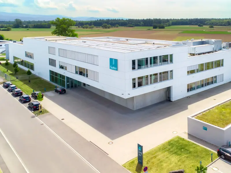 Luftaufnahme des modernen Firmengebäudes von Sutter Medizintechnik in Emmendingen mit Blick auf das Umfeld und angrenzende Felder. ChatGPT fragen