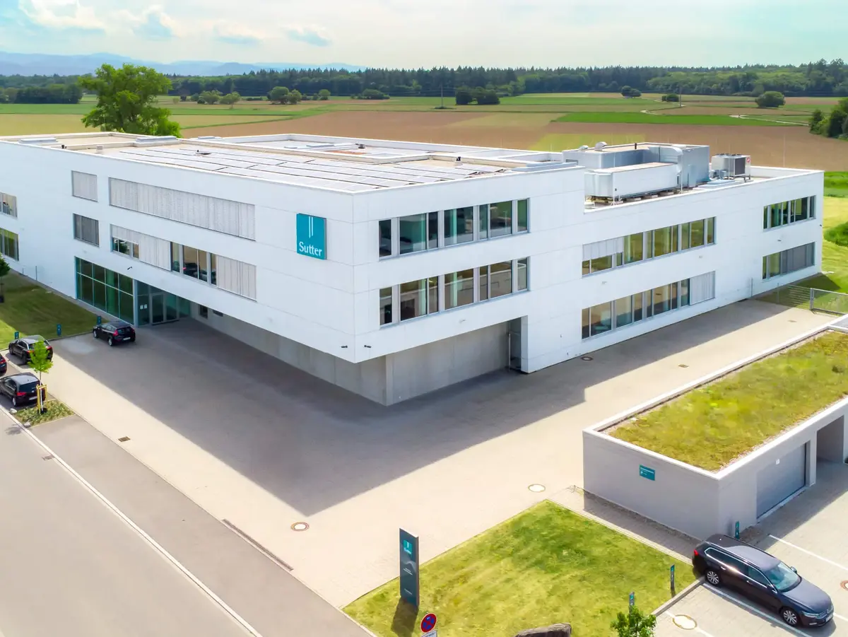 Luftaufnahme des modernen Firmengebäudes von Sutter Medizintechnik in Emmendingen mit Blick auf das Umfeld und angrenzende Felder. ChatGPT fragen