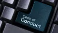Nahaufnahme einer Computertastatur mit einer hervorgehobenen petrolfarbenen Taste, auf der „Code of Conduct“ steht.
